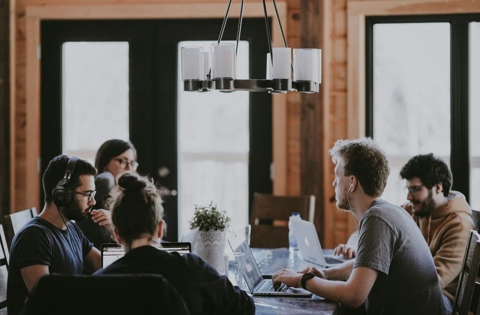 A small team discussing work at a table in a characterful studio.