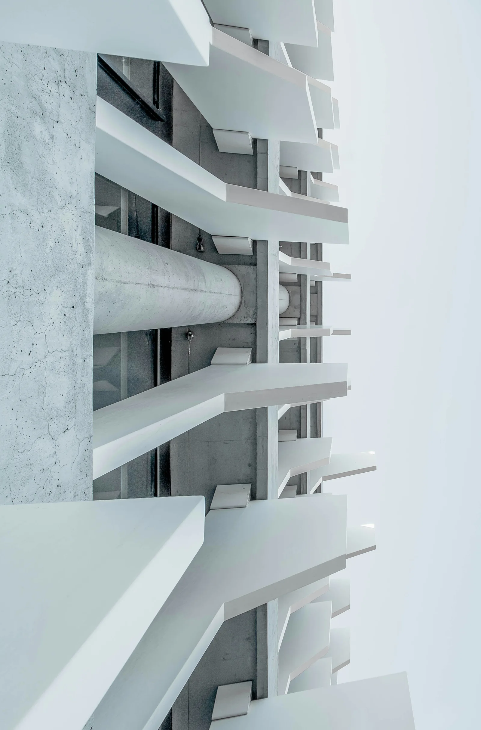 Layered white concrete balconies and repeating geometric openings.